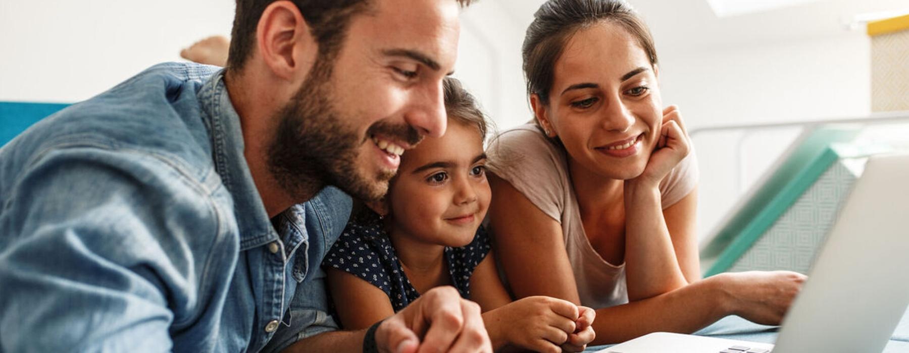a family looking at a laptop