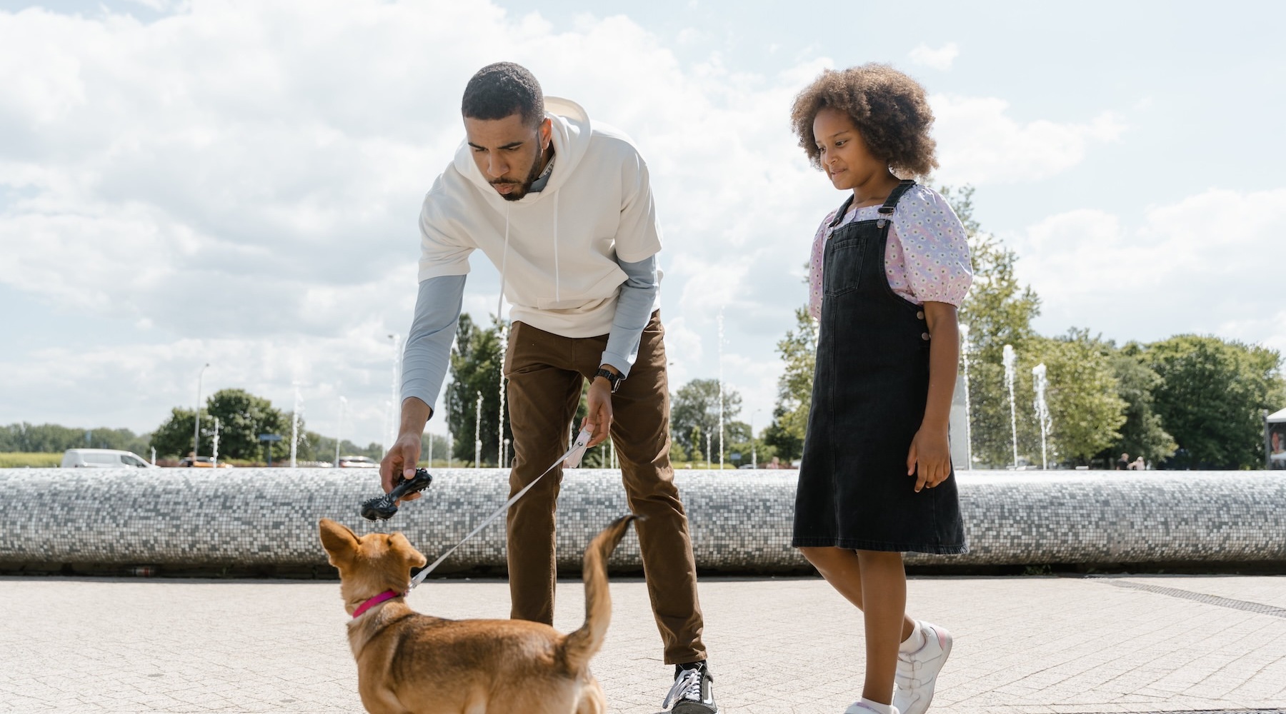 a father and daughter walking their dog