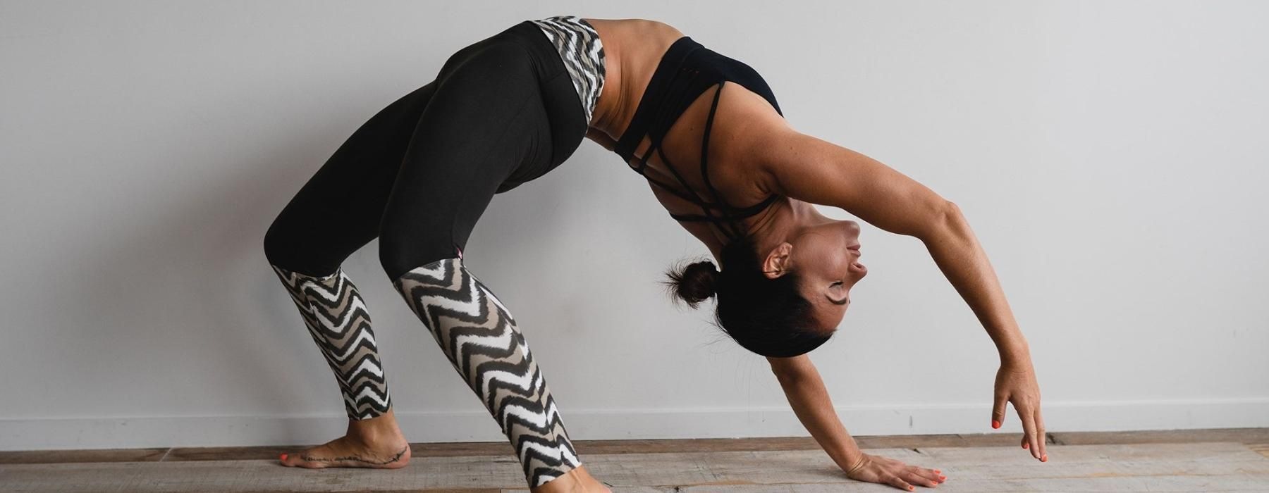 woman bending over backwards in an exercise studio